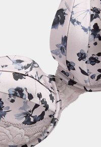 Soutien-gorge à motif floral dans des nuances de rose pâle et de bleu marine ; dotée de bonnets rembourrés, d'une délicate bordure en dentelle et d'un tissu satin lisse avec des coutures structurées.