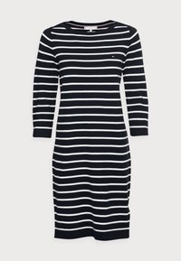 Robe rayée aux couleurs bleu marine et blanc, col rond, manches longues et coupe ajustée. Fabriquée en maille douce.