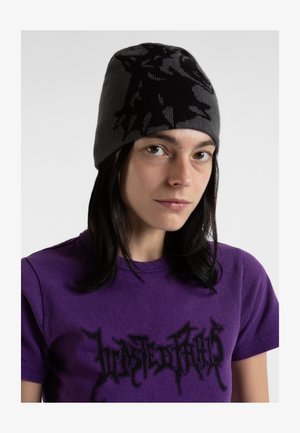 Gorro de punto gris con un diseño de lobo negro. La persona lleva una camiseta morada con texto estilizado negro. Textura suave y forma ajustada.