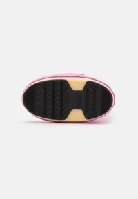 Sneaker rosa con suola in gomma; presenta un fondo nero texturizzato per una presa migliore e un interno imbottito con una intersuola color crema.
