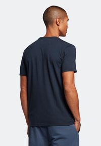 T-shirt a maniche corte blu navy, in morbido cotone, con girocollo, silhouette attillata, design semplice senza motivi o accenti visibili.