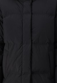 Black puffer jacket featuring a quilted design, smooth texture, and a high collar. Front pockets and concealed zip closure.