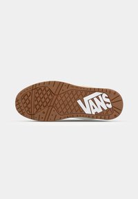 VANS sneakersåle i gummi med teksturert mønster, og med en hvit logo. Runde kanter og robust konstruksjon er synlige.