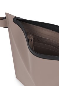 Borsa color taupe chiaro con design geometrico, zip nera e interno testurizzato. Presenta una tasca interna e materiale resistente.