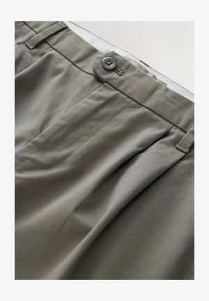 Světle šedé chinos kalhoty s hladkým povrchem, obsahující knoflíkové zapínání, záhyby na přední straně a klasické kapsy.