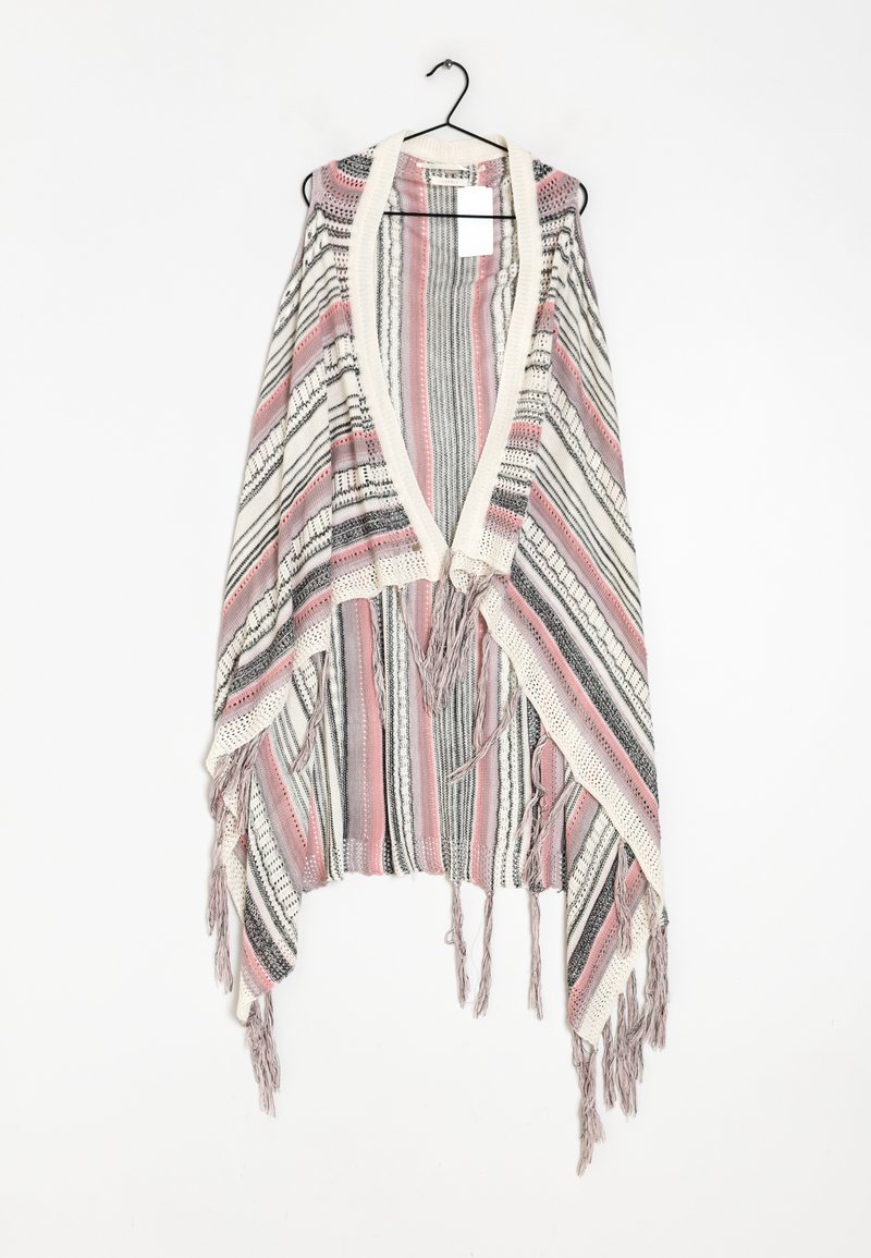 Poncho tricoté à rayures rose, noir et blanc, avec un col en V et des franges, suspendu à un cintre noir.