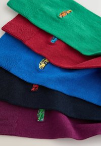 Stapel von fünf gefalteten Socken in Grün, Rot, Blau, Schwarz und Violett, jede mit einem kleinen bunten Auto nahe der Manschette bestickt.