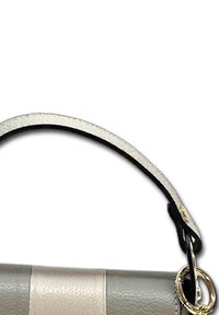 Leren handtas met een lichtgrijs en crèmekleurig ontwerp, een gestructureerde vorm, een zwarte leren schouderband en gouden hardware accenten.