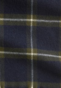 Wollplaidstoff mit dunkelblauem Hintergrund, grün-weißem Karomuster und einer weichen, strukturierten Optik.