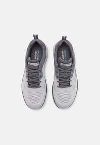Lightweight gray athletic shoes with mesh upper, dark gray accents, and flat laces. Features "SKECHERS" branding and cushioned insole.