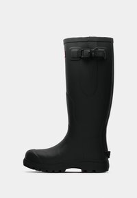 Botas de lluvia de goma negra con punta redonda, suela texturizada y una correa ajustable en la parte superior. Presenta una superficie lisa y un caño alto.