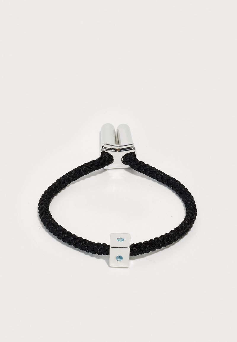 Must mustriin ja pärapne vahe-omaarist hele hallik - rohelise gerani vööst paretise ja disaini ning sobivase kehelise ja moes. Kaks sinist juveeli on kahe ringi omavahelise kuld lisen.