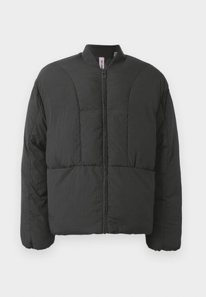 Veste matelassée noire avec un col haut, fermeture éclair frontale et deux grandes poches latérales. Elle présente un tissu lisse et léger avec un design matelassé.