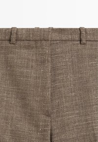 Braune Leinenhose mit strukturierter Oberfläche, flachem Bund und Gürtelschlaufen, mit einem maßgeschneiderten, geraden Beinchnitt.