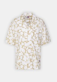 Camicia a maniche corte di colore beige con un motivo floreale bianco. Presenta un colletto, una lista di bottoni e una tasca sul petto sul lato sinistro.
