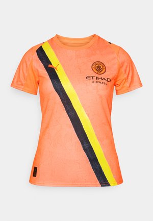 Oranssi urheilupaita, jossa on mustia ja keltaisia vinoraitoja, Manchester Cityn logo ja Puma-brändäys vasemmassa olkapäässä.