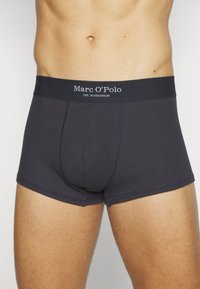 Tummansiniset boxerit, joissa on ribbikuvio, joustava vyötärö, jossa on "Marc O’Polo"-logo, sekä muotoiltu malli mukavuutta ja tukea varten.