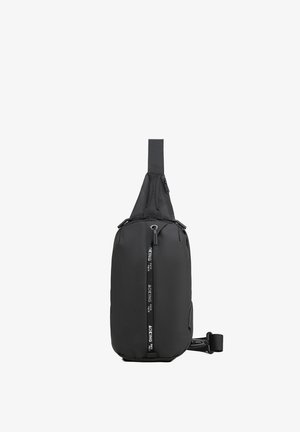 Sac à dos en bandoulière noir en tissu durable. Caractérisé par une fermeture éclair, une sangle réglable et des détails de logo sur le côté. Design compact et épuré.
