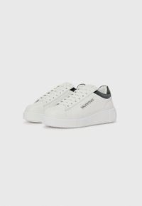 Hvite lær sneakers med en teksturert hvit plattformsåle, svarte helldetaljer og trykt logo på siden. Klassisk snøring.