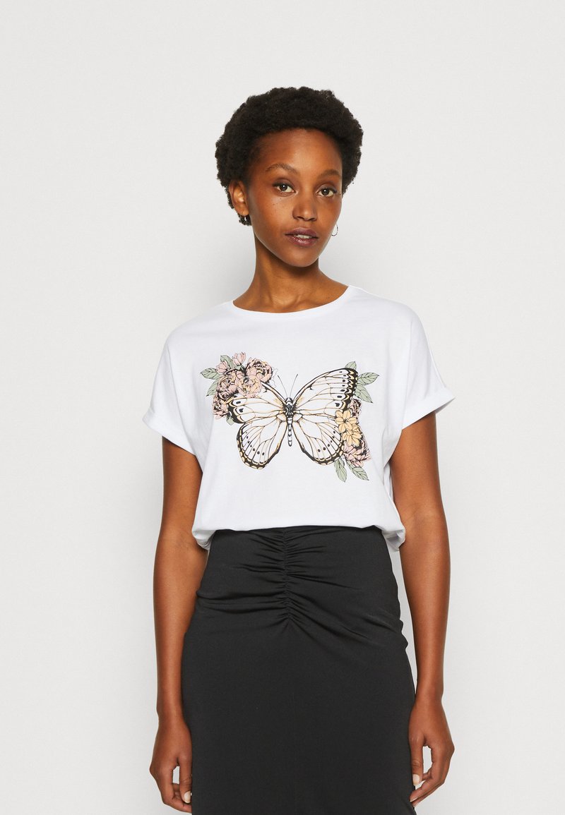 White T-shirt featuring a butterfly and floral graphic in black, pink, and green. Short sleeves, relaxed fit, soft fabric. Black skirt.