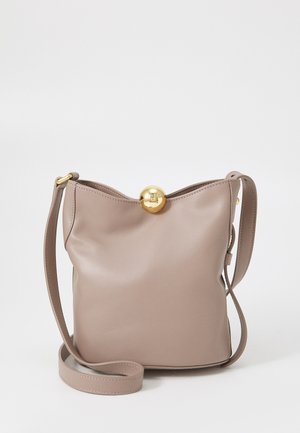 Light beige leather handbag with a structured design, rounded gold hardware closure, and a thin, adjustable shoulder strap.