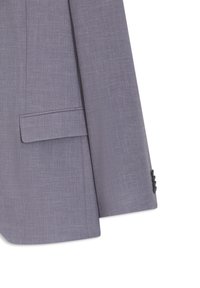 Μανίκι και τσέπη με καπάκι από γκρι σακάκι, εμφανίζοντας υφή και τρία μαύρα κουμπιά στη μανσέτα σε λευκό φόντο.