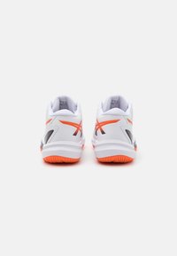 Witte sportschoenen met oranje accenten, voorzien van gestructureerde zolen, een gevoerde kraag en slanke ontwerpelementen voor extra ondersteuning.