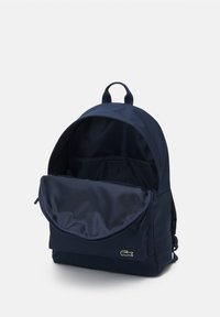 Sac à dos bleu marine en tissu durable, avec un compartiment principal à fermeture éclair, une poche avant et un accent de logo.