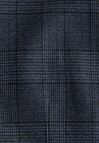 Tissu à carreaux marine présentant un tissage texturé avec des motifs de carrés alternant entre bleu clair et bleu foncé, rehaussé de fines lignes noires.