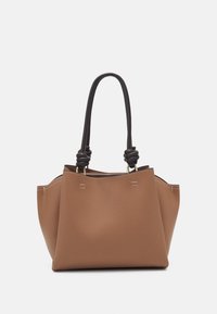 Sac fourre-tout en cuir marron à surface texturée, avec deux anses noires nouées et des coutures décoratives. Conception à ouverture supérieure, intérieur spacieux.