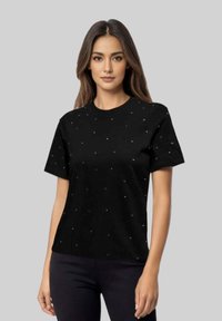 Camiseta negra de manga corta con escote redondo, que presenta acentos dispersos de pedrería para añadir textura y detalle. Acabado de tela suave.