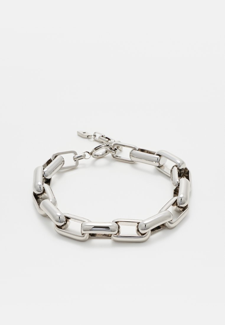 Bracelet en métal argenté avec des maillons allongés au fini poli et un fermoir à ressort. Surface lisse avec texture réfléchissante.