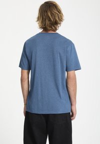 Blå meleret t-shirt med korte ærmer og rund halsudskæring. Blødt, letvægtsstof. Bagansigtet viser en afslappet pasform og minimale sømdetaljer.