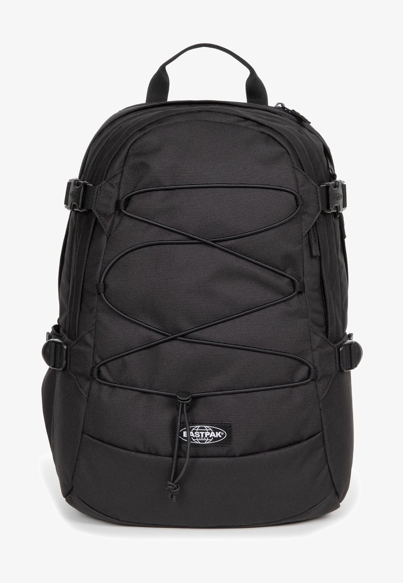 Mochila negra con un tejido texturizado, que cuenta con cuerdas bungee elásticas, hebillas laterales y un parche de logo prominente en la parte frontal.