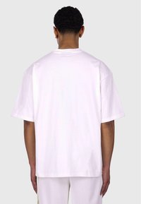 Hvid bomulds t-shirt med en afslappet pasform, korte ærmer og en lige kant. Bagsiden er ensfarvet uden synlige grafik eller mønstre.