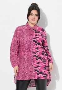 Rosa Hemd mit Knopfleiste und geteilter Gestaltung: Eine Seite im Leoparden-Design, die andere Seite in rosa Camouflage. Lange Ärmel und abgerundeter Saum.