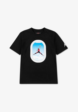 T-shirt noir avec un graphisme d'un joueur de basketball sautant pour un dunk, encadré par la forme d'une fenêtre d'avion au centre devant.