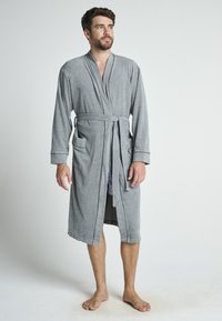 Accappatoio grigio in cotone con maniche lunghe, di lunghezza media, dotato di cintura e due tasche frontali. Texture liscia, design semplice.