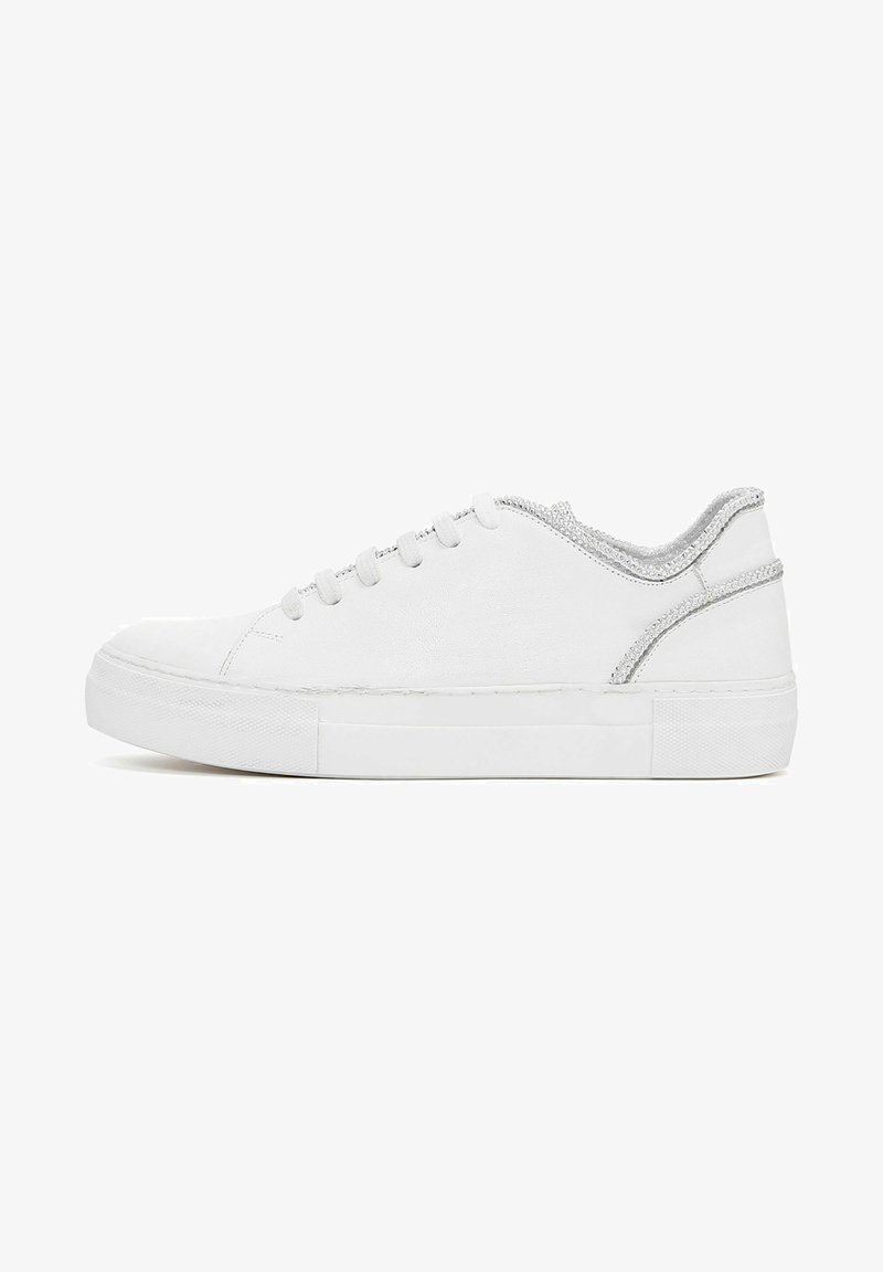 Witte sneaker met een platte zool, bovenwerk van textuurstof, zilveren accenten langs de kraag en een klassieke vetersluiting.