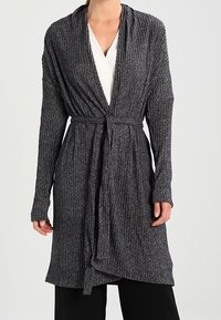 Dlouhý cardigan s otevřeným předním dílem vyrobený z ribbané šedé látky, s dlouhými rukávy, páskem v oblasti pasu a splývavým designem s jemnou texturou.