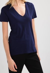 Mörkblå kortärmad T-shirt med V-hals i mjukt bomullsmaterial, med en avslappnad passform och slät yta.