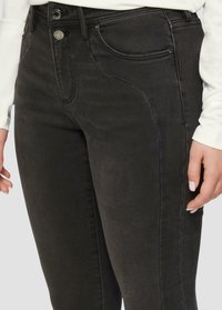 Zwarte denim jeans met een hoge taille, voorzakken en een aansluitend design. De stof heeft een lichte glans en een gladde textuur.