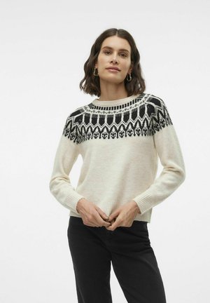 Pull léger en crème avec un empiècement noir à motifs, fabriqué en matériau doux avec des poignets et un ourlet côtelés. Coupe décontractée et manches longues.