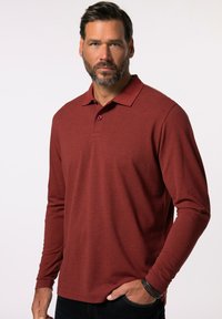 Langärmliges Polo-Shirt in Burgunderrot, aus strukturiertem Stoff, mit einem Kragen, einer Knopfleiste mit drei Knöpfen und kontrastierenden pinken Knöpfen.