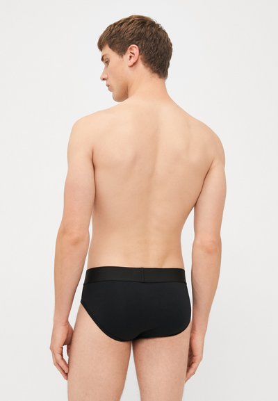 Caleçons noirs pour hommes en tissu lisse avec une ceinture élastique. Le tissu est élégant et ajusté, mettant en valeur un design minimaliste sans motifs visibles.