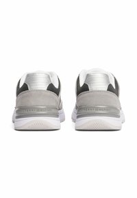 Szare zamszowe i siateczkowe sneakersy z białymi akcentami, z metaliczną osłoną pięty i logo "TOMMY HILFIGER" z tyłu, zaprojektowane z myślą o komforcie.