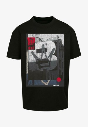 Maglietta in cotone nera con un design grafico caratterizzato da accenti rossi, che raffigura un numero "2" stilizzato e una corona su uno sfondo texture.