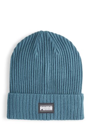 Knitted beanie in teal with a ribbed texture. Features a fold-up cuff and a black label with white "PUMA" branding.