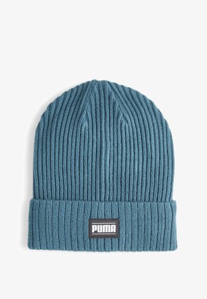 Knitted beanie in teal with a ribbed texture. Features a fold-up cuff and a black label with white "PUMA" branding.