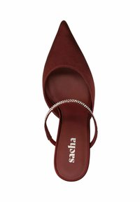 Chaussure rouge en satin à bout pointu avec une ouverture à l'arrière et une bride de cheville décorative accentuée de silver. Texture lisse, design minimal.
